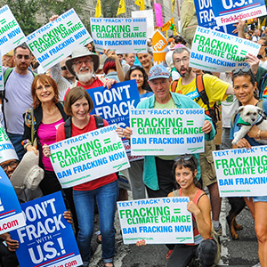 Activists holding signs calling for a national ban on fracking.