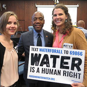 Activists and elected officials in Baltimore holding a sign saying "Water is a human right".