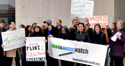 Wenonah Hauter and Food & Water Action activists with signs outside the Health & Human Services building in Washington, DC.