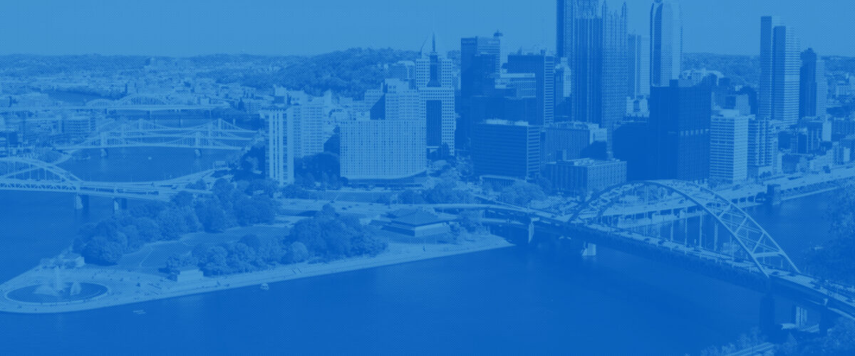 Downtown Pittsburgh, with a river and bridge in front of it.