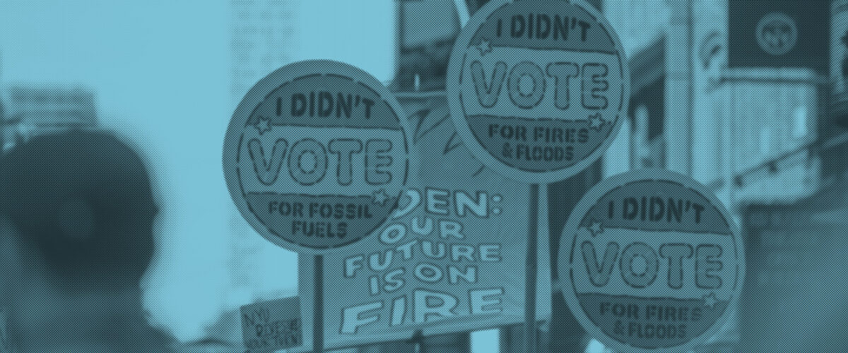 Signs at a rally read "I didn't vote for fossil fuels."