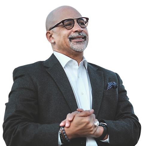 Chris Rabb wears a black suit, black spectacles, and clasps his hands as he smiles.